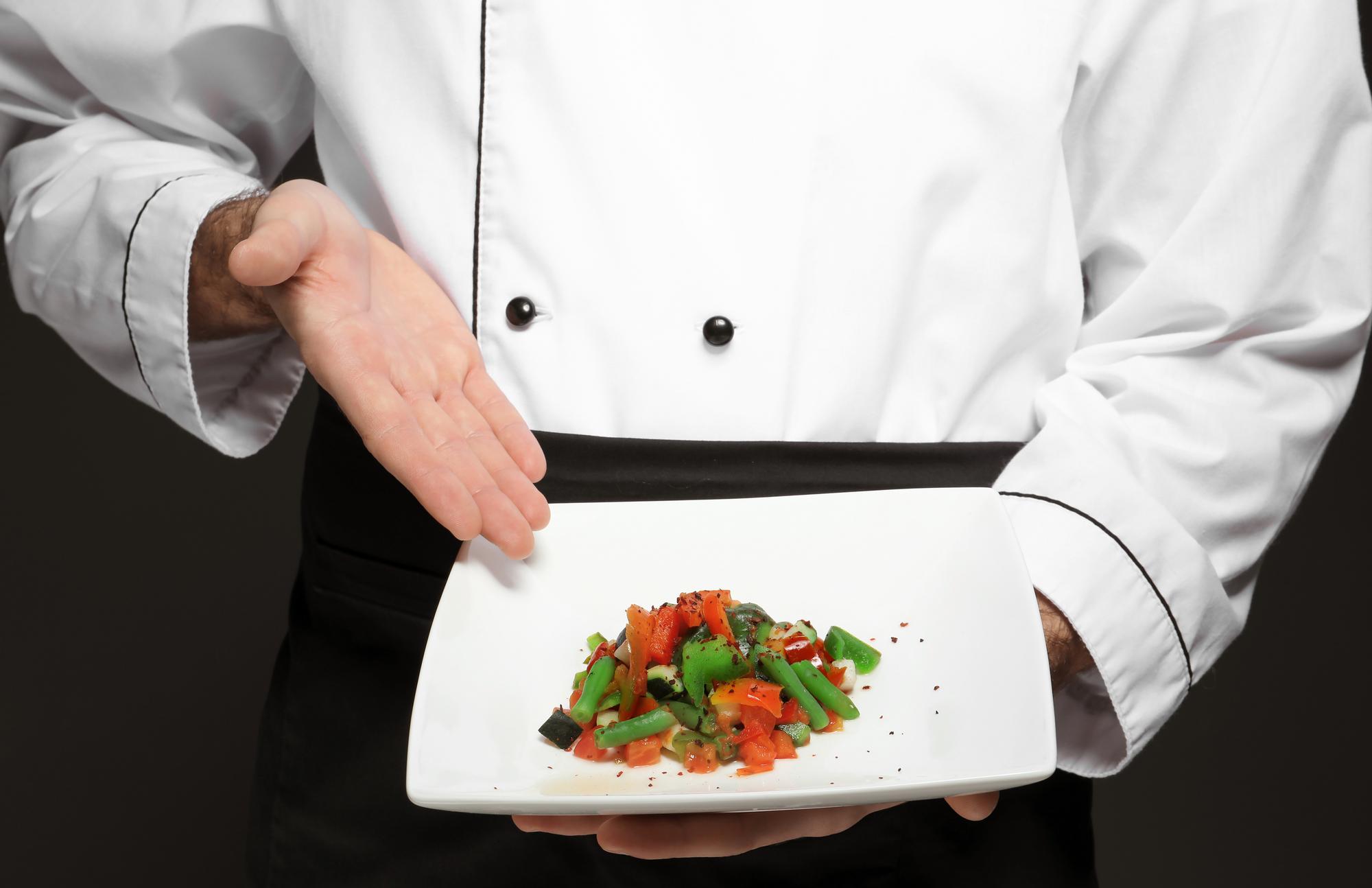 Chef preparing plated dish in elegant kitchen